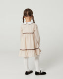 Back view full body of toddler girl with pigtail braids wearing sand striped dress with white collar, black mary jane shoes and white tights, studio background