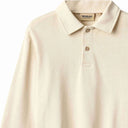 Close up of off white polo shirt collar, button placket and Wheat label
