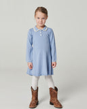 Girl in light blue ribbed knit dress with quilted vest and cowboy boots holding hands with boy in denim jacket, wood paneled room