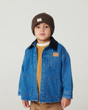 Toddler boy wearing indigo denim jacket with black corduroy collar, brown ribbed beanie and mustard sweater, studio portrait on white background