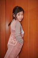 Pink corduroy overalls with square lace trimmed neckline, flat lay front view on white background