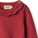 Close up of cherry red knit dress collar with Wheat label and button detail