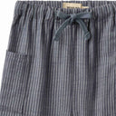 Close up of grey pinstripe trousers waistband with drawstring tie and Wheat label patch