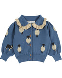 Dusty blue jacquard cardigan with white sheep and border collie pattern and ruffle collar, front view