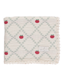 Woven blanket with red apple pattern on a white background