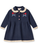Navy blue dress with rose and bow embroidery on a white background