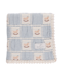 Rocking horse embroidered baby blanket in blue and cream patchwork, folded flat lay