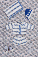 Cream cardigan and bloomer set with blue floral stripe pattern, flat lay with matching blanket, bonnet, wooden pull toy, and socks on floral fabric