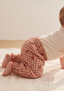 Baby crawling in red and cream gingham check pants with floral embroidery and ruffle cuffs