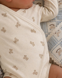 Close up of baby wearing cream teddy bear print kimono wrap onesie