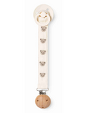 Cream pacifier clip strap with embroidered teddy bear faces, wood clip and pacifier attached, flat lay