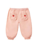 A pair of light pink children's pants with elastic waist and cuffs, featuring two back pockets decorated with small red strawberry details, shown against a plain white background.