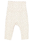 A pair of baby leggings in a warm cream color, featuring a dense, all-over pattern of tiny brown and beige stars and dots, laid flat against a solid white background.