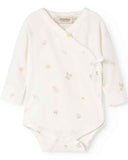 White baby onesie with small colorful patterns on a white background