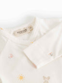 Close up of cream kimono onesie collar and cuff with MarMar Copenhagen brand tag and tiny toy print