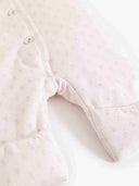 Close up of pink floral duvet suit sleeve with folded cuff and scalloped trim