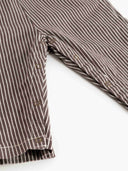 Close up of striped overalls side snap closure at pant leg