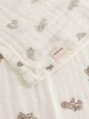 Close up of cream muslin swaddle corner with tan teddy bear print and MarMar Copenhagen tag