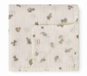 Cream muslin swaddle blanket with tan teddy bear print, unfolded flat lay