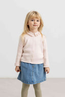 Toddler girl wearing pale pink ribbed knit cardigan with ruffled collar, paired with denim skirt and sage tights, standing indoors