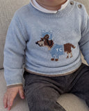Close up of toddler wearing horizon blue wool pullover with dachshund dog intarsia motif over a white collared shirt