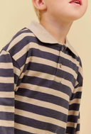 Close-up of a child wearing a long-sleeve polo shirt with horizontal navy and beige stripes, featuring a solid beige collar and a two-button placket.